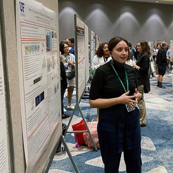 Student presenting their poster at a meeting