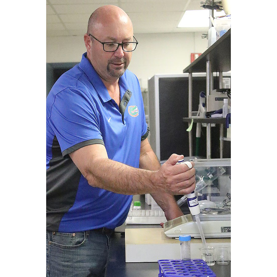 Man measuring soil in a lab, photo credit: Christine Rodenbaugh