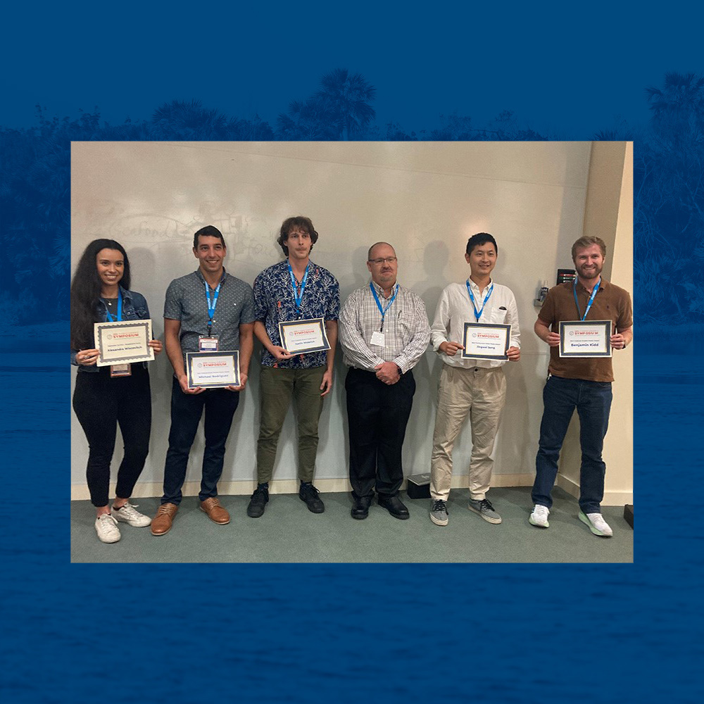 Group of people holding their awards for best posters at the UFGI Symposium