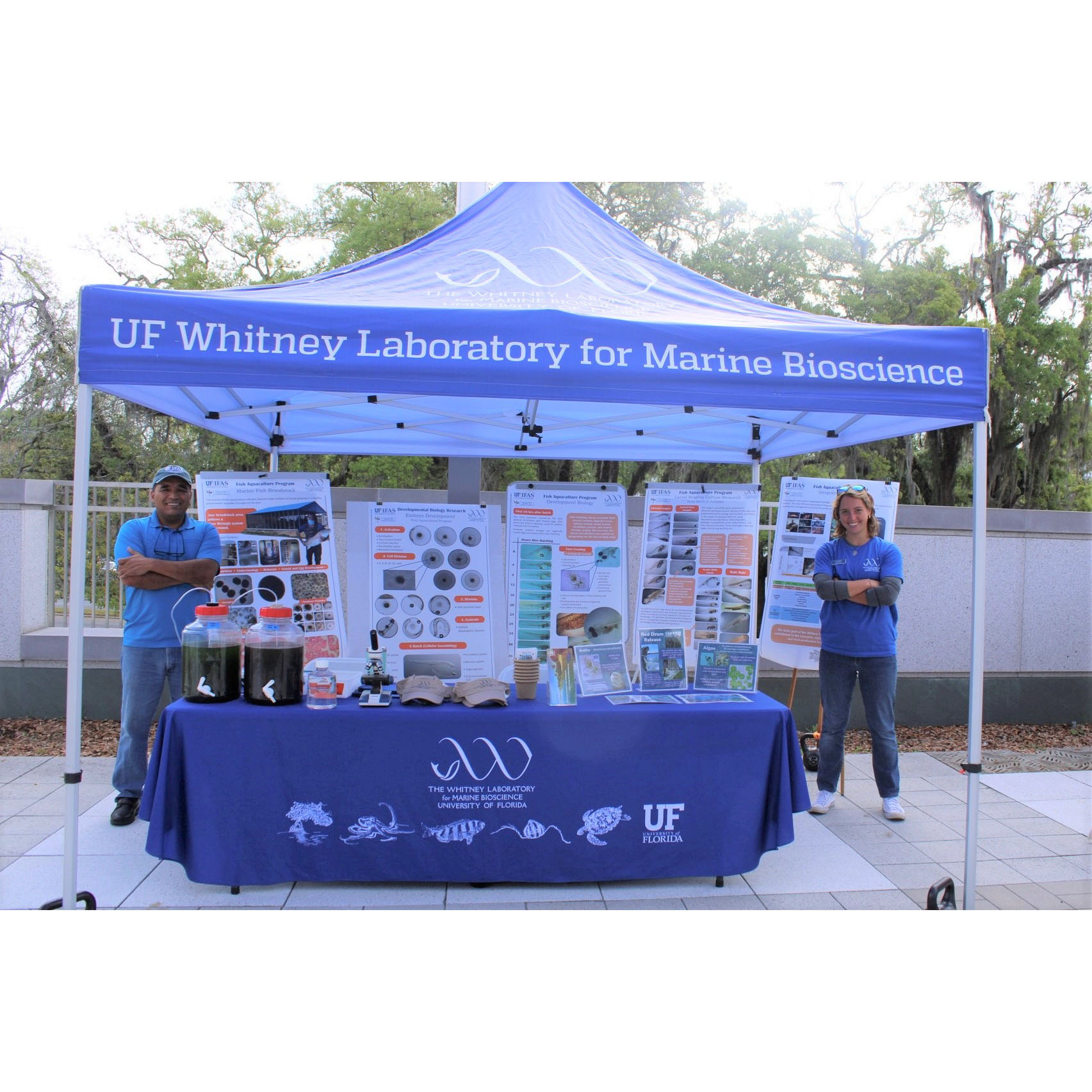 Two people stand on either side of a Whitney Laboratory tent