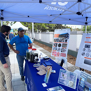 Two individuals look at information under a display tent