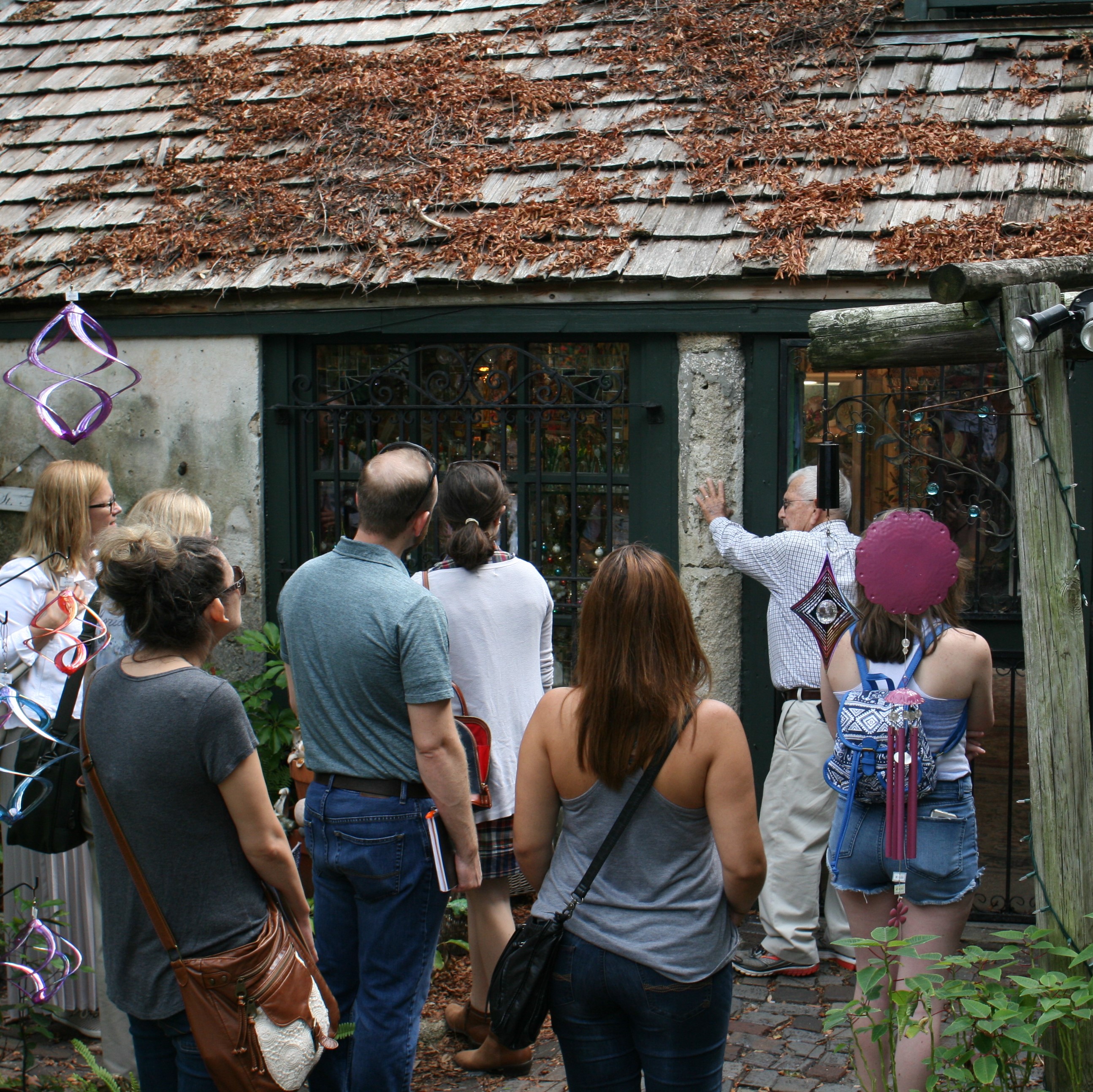 Group of people being shown the exterior of a historic building