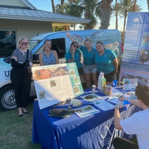 Sea Turtle Hospital staff standing at their booth at Taste of the Fun Coast event.