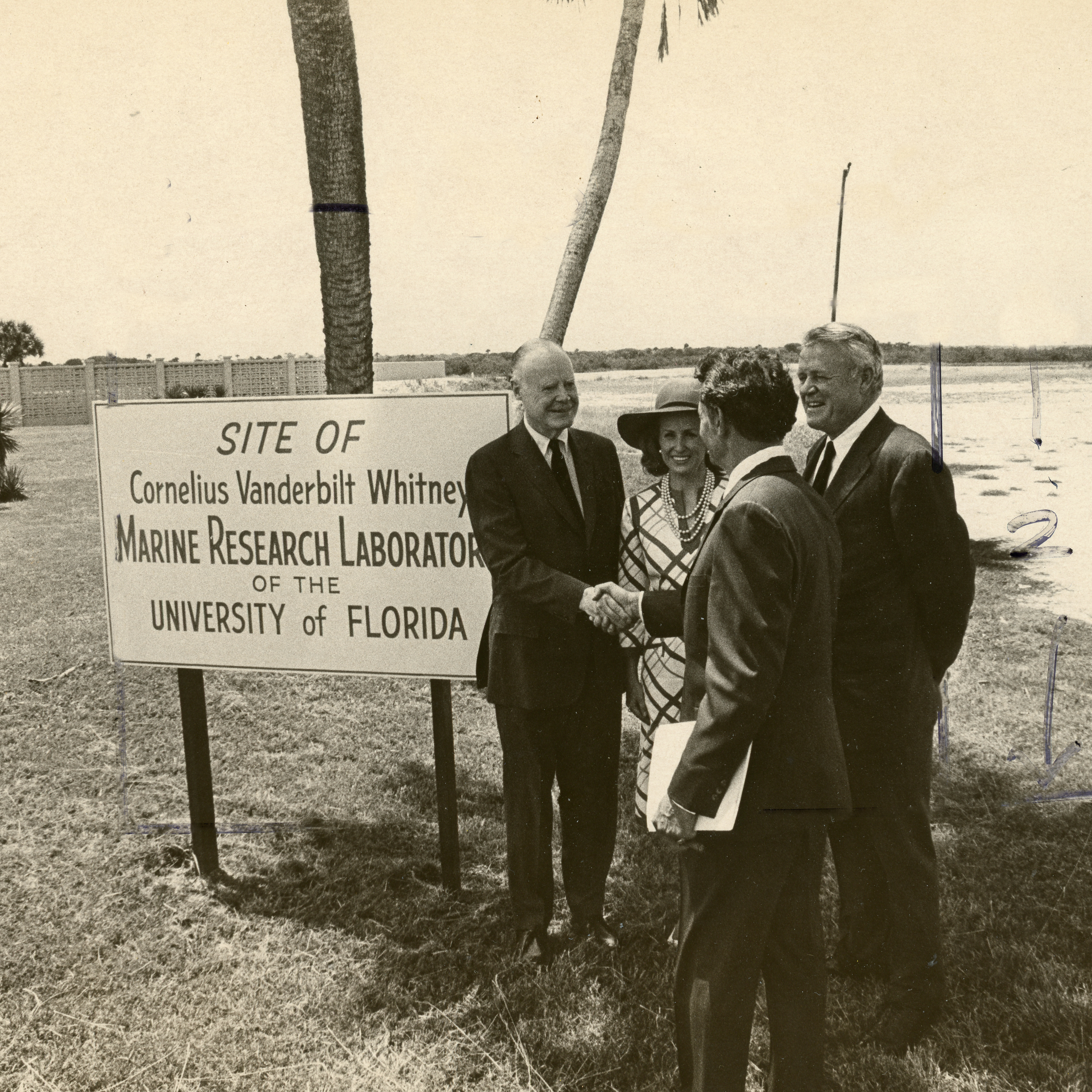 Group of people standing in front of sign for future site of Whitney Laboratory