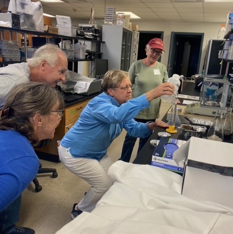 Group of people in a laboratory setting looking at lab experiment