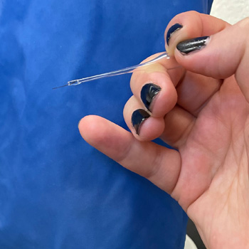 Hand holding eyelash tool
