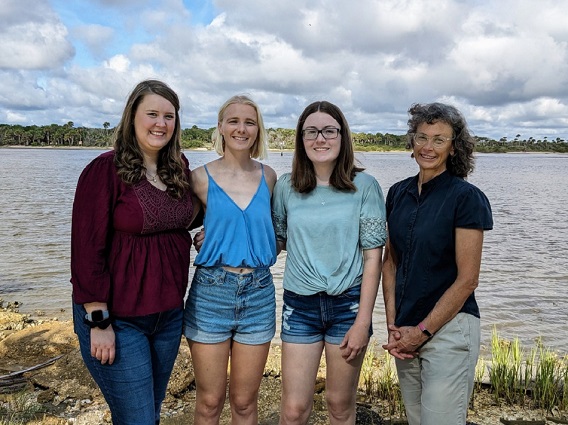 Group of students and faculty member standing in front of estuary